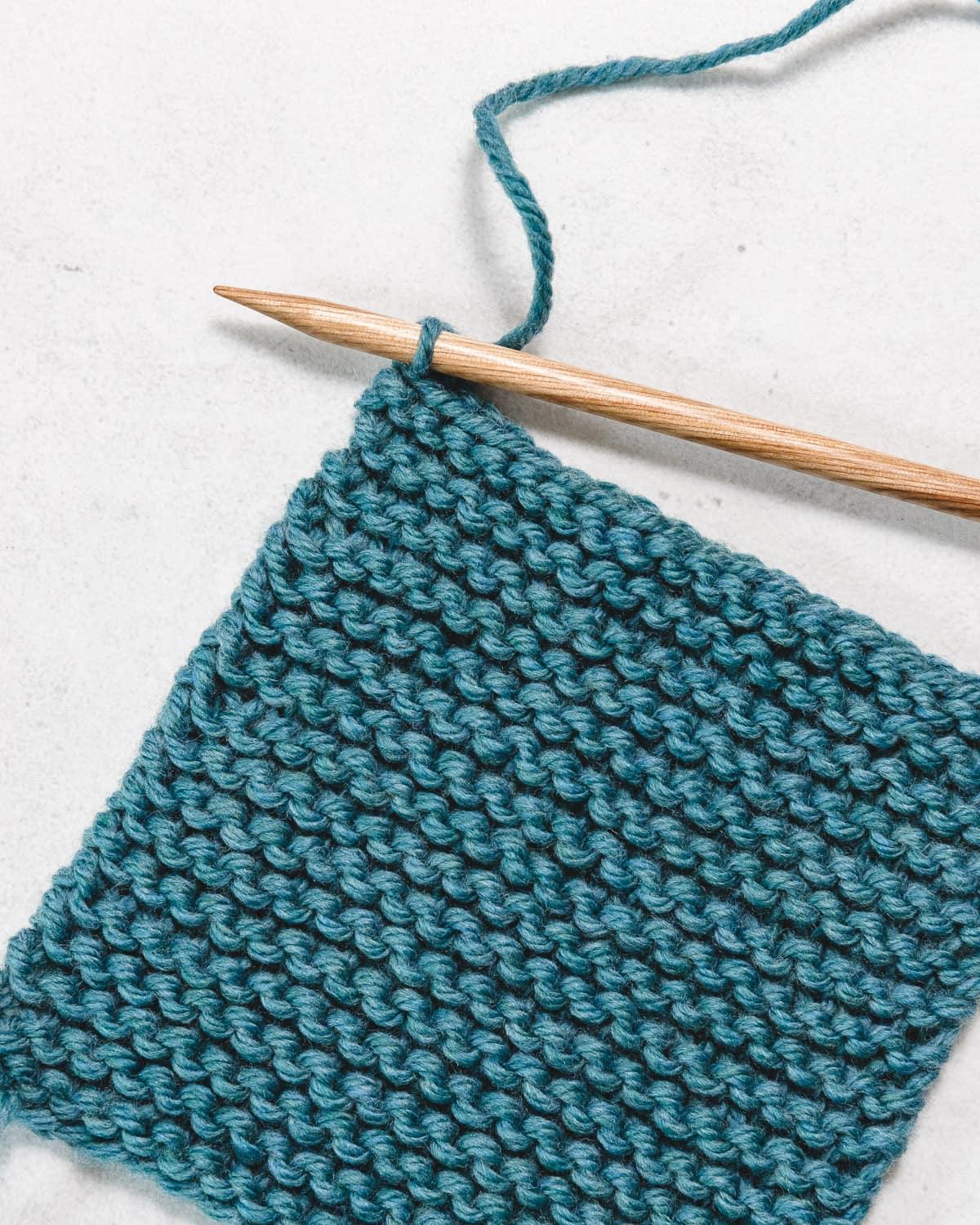 a swatch of garter stitch with all stitches cast off, and one loop left on the knitting needle