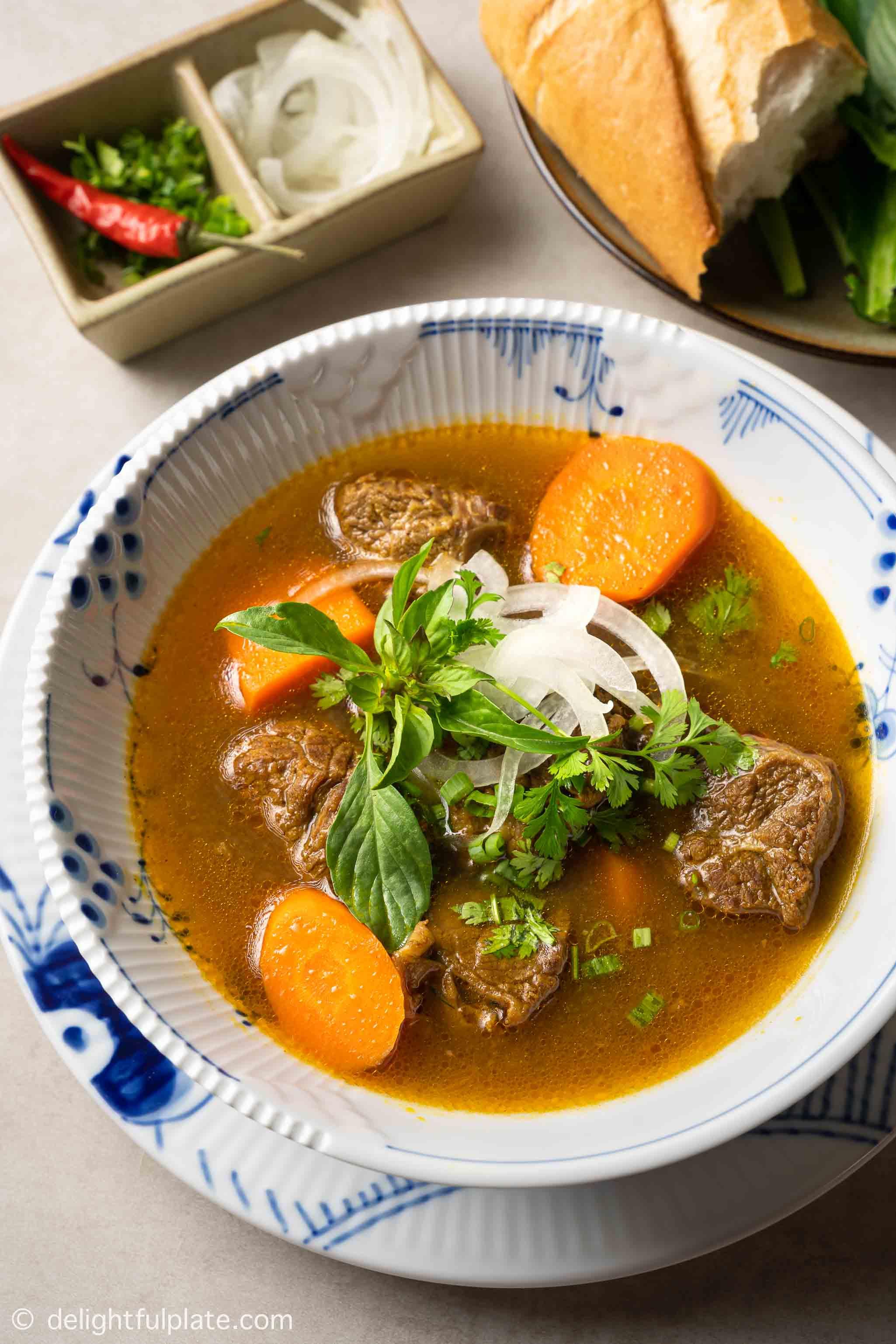 a bowl of bo kho (Vietnamese beef stew) served with banh mi