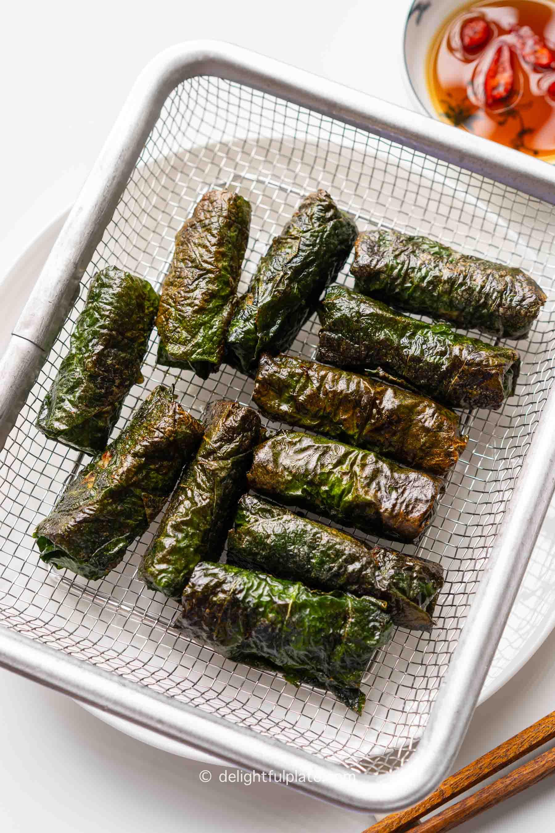 a plate of Vietnamese pork rolls in wild betel leaves (cha la lot).